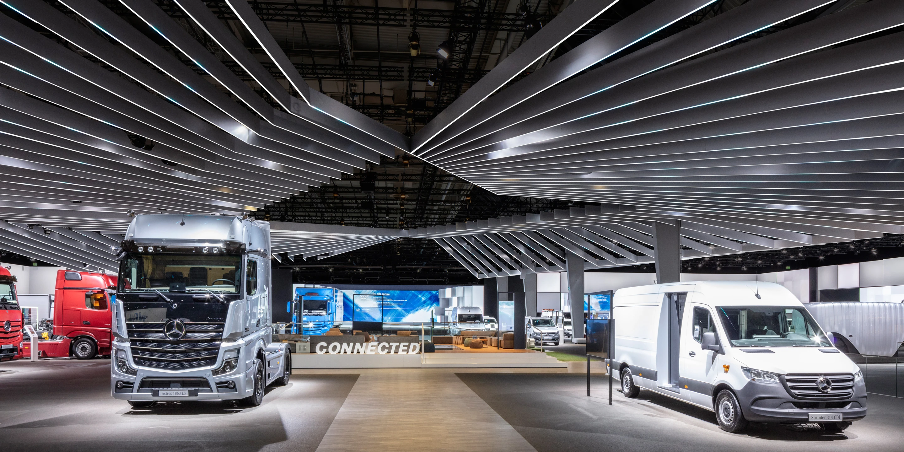 Ausbau, Temporär, Freiform, Innenraum, Holz-Stahl-Tragwerk, Lamelle, LED, Lichtinstallation, Lichtdecke, Bühne, Privat, Großprojekt, öffentlich zugänglich, Ausstellung, Gastronomie, Shop, Büros, IAA, Hannover, Nutzfahrzeuge, Daimler, Mercedes-Benz, Messen, Markenauftritt, Messeauftritt, Trucks, Fuso, Setra, Standfläche, Deckenkonstruktion, medial, Highlight, e-Mobility, Fleetboard, Actros Highlight, Powertrain, MB Pro, Digital Services/Omniplus, Kommunikation, Hauptbühne, Markenwand, Medienfläche, Trucks and Busses for the world,   Intro Bereich, Architektur, KTP, Kauffmann Theilig Partner, Freie Architekten PartGmbB, Stuttgart, MUTABOR, DISPLAY INTERNATIONAL, Markus Bollen 
