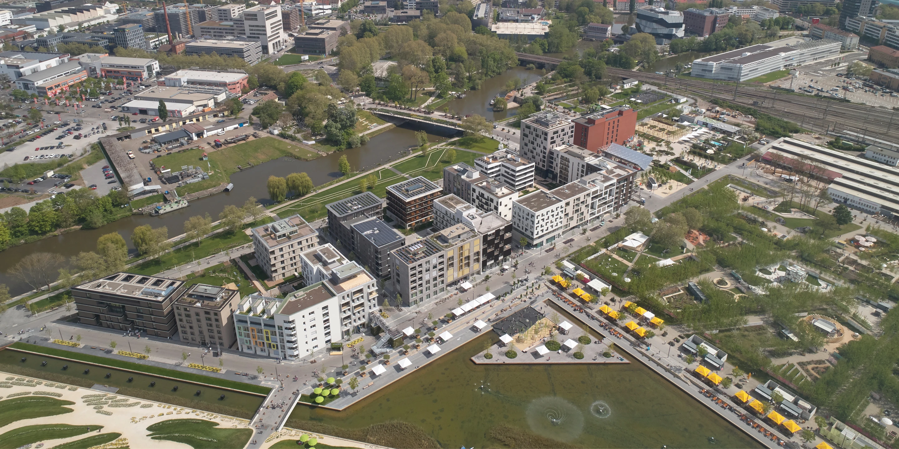 Wohnen auf Zeit Neckarbogen | Heilbronn Eckgebäude, Innerstädtisch, Neubau, Städtebau, Betontragwerk, Fertigteile, Lamelle, Metallfassade, Flachdach, Tiefgarage, Innenhof, Balkone, Investor, öffentlich zugänglich, Lamelle, Wohnen, Café, Service, Quatier, Gastronomie, Neckarbogen, Heilbronn, Quartier, Baordinghouse, Wohnung, Loggia, Dachlandschaft, Wohnungen, BUGA-Gelände, Fassade, Architektur, KTP, Kauffmann Theilig Partner, Freie Architekten PartGmbB, Stuttgart,