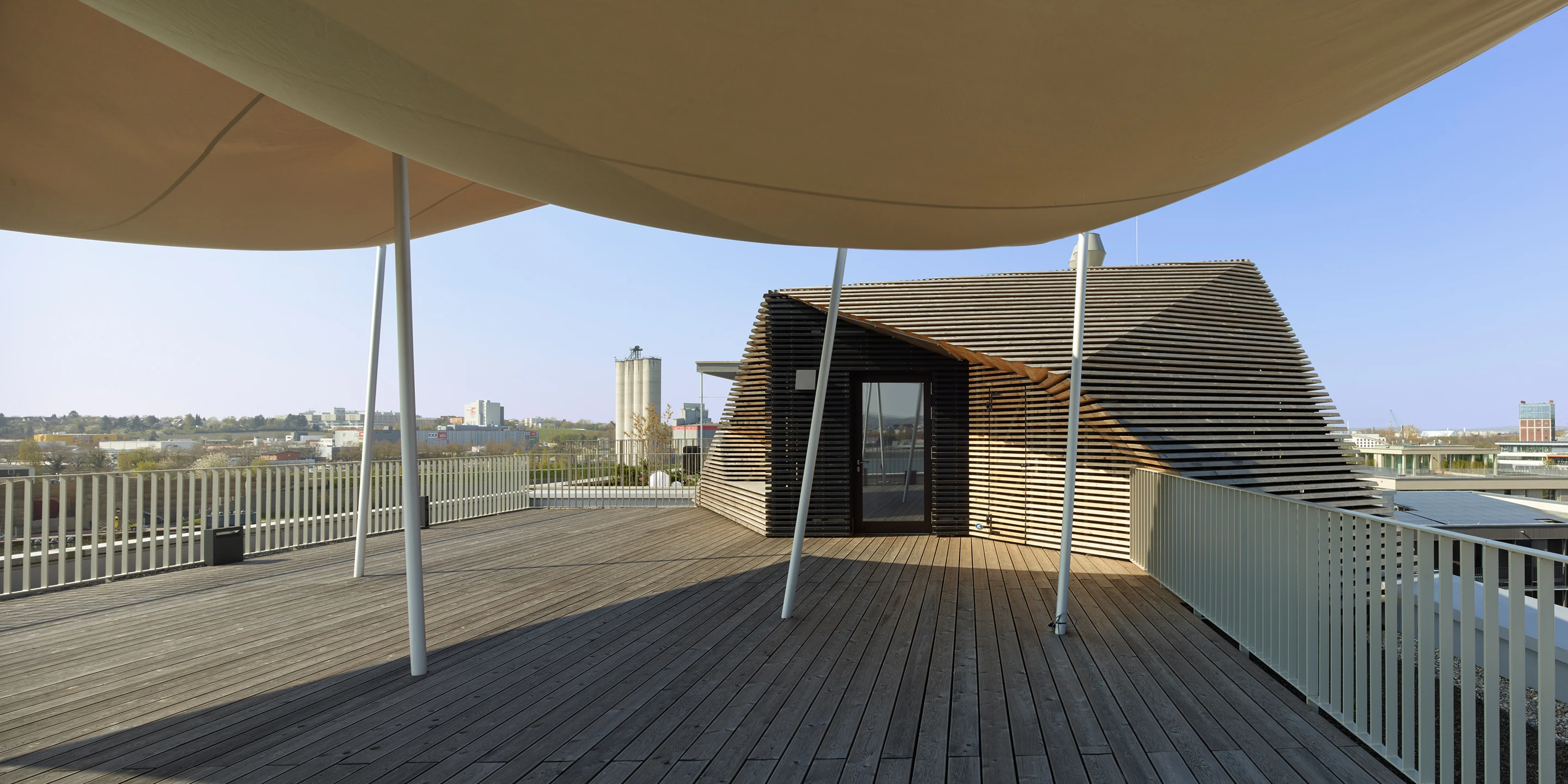 Wohnen auf Zeit Neckarbogen | Heilbronn Eckgebäude, Innerstädtisch, Neubau, Städtebau, Betontragwerk, Fertigteile, Lamelle, Metallfassade, Flachdach, Tiefgarage, Innenhof, Balkone, Investor, öffentlich zugänglich, Lamelle, Wohnen, Café, Service, Quatier, Gastronomie, Neckarbogen, Heilbronn, Quartier, Baordinghouse, Wohnung, Loggia, Dachlandschaft, Wohnungen, BUGA-Gelände, Fassade, Architektur, KTP, Kauffmann Theilig Partner, Freie Architekten PartGmbB, Stuttgart,